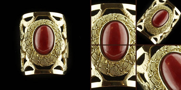 Anello in oro con pietra ovale rossa e montatura lavorata a mano